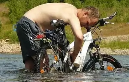 миття велосипеда в річці