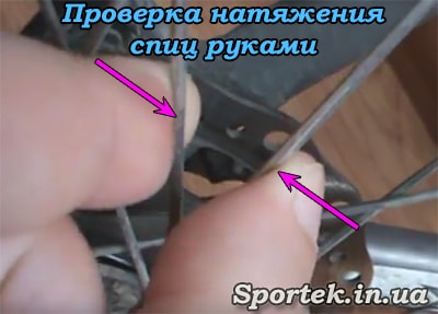 Перевірка натягу спиць в колесі велосипеда пальцями рук 