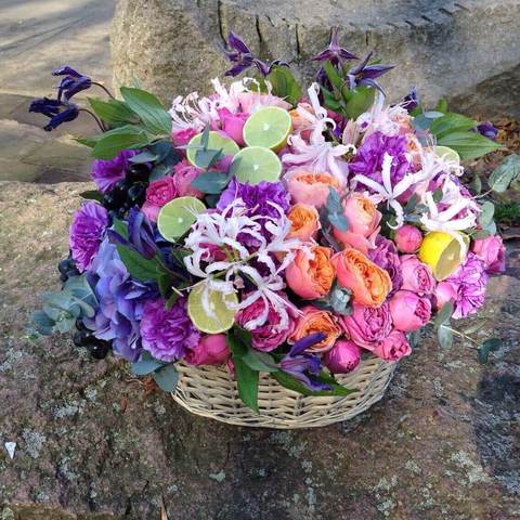 Luxurious basket with flowers and fruit additions, Bright basket of flowers