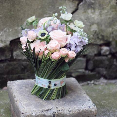 A gentle sheaf in heavenly colors with delphinium and roses, Delicate bouquet of pink roses in balgrass