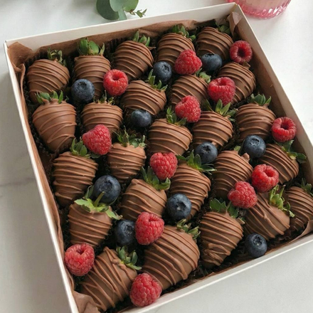 Полуниця у молочному шоколаді з ягодами малини та лохини